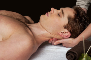 Young man receiving head massage at health spa
